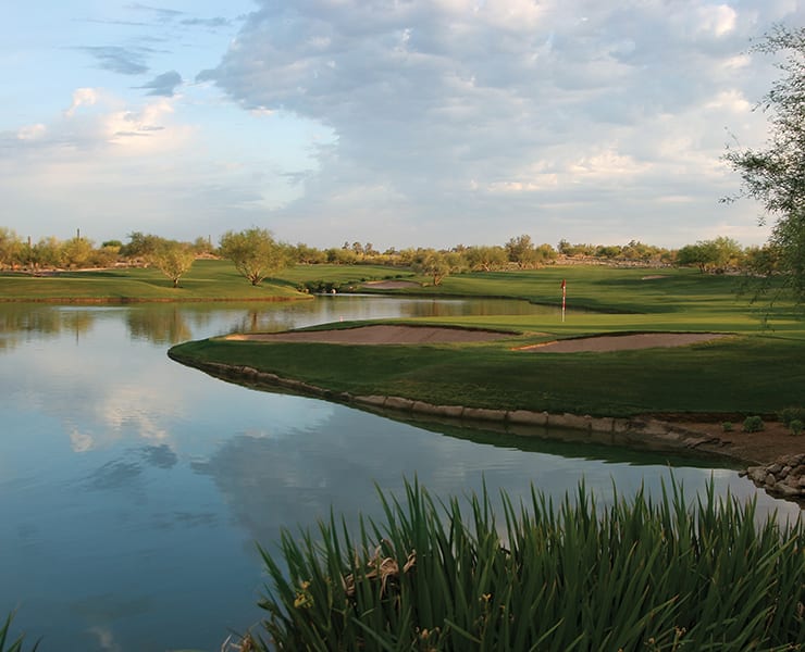 Golfers on the 18th hole of Grayhawk Golf Club's Raptor Course which features sloping greens and a water hazard